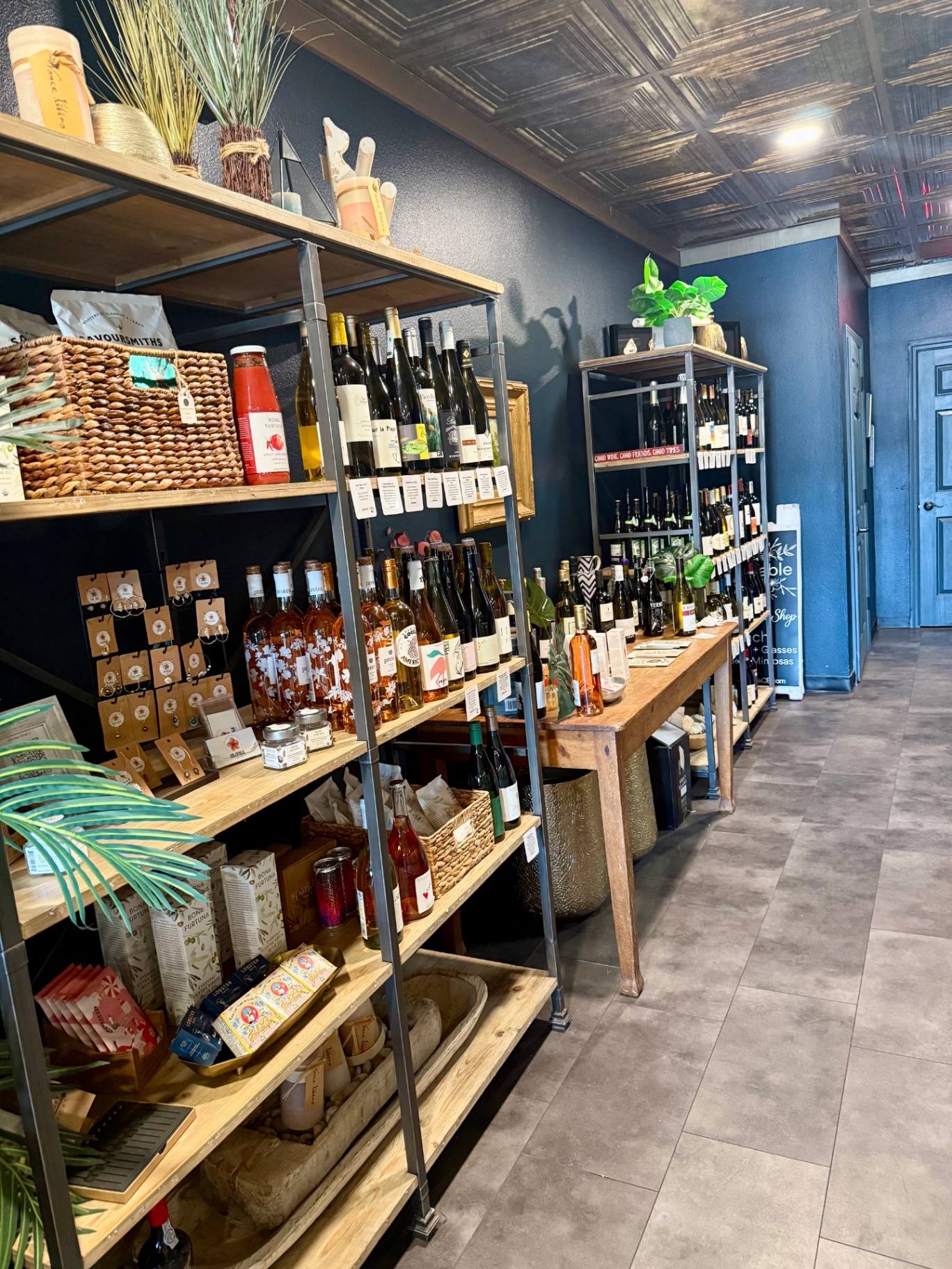 Floor-to-ceiling wine shop shelves stocked with small-producer bottles